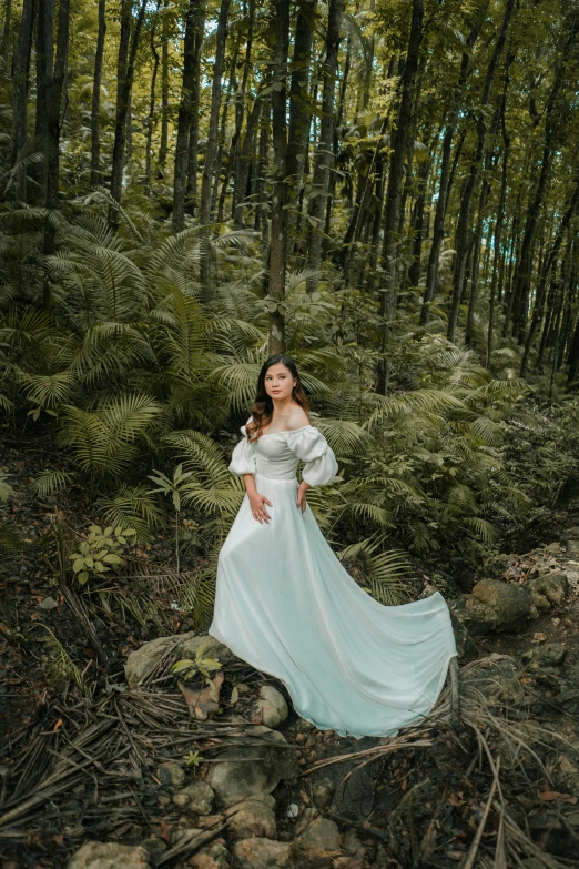 a woman standing in front of some trees