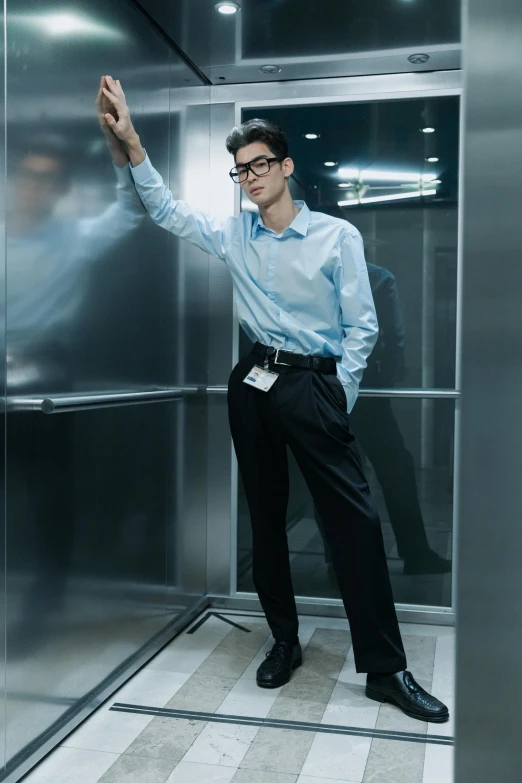 a man with his arms outstretched, leaning against an elevator