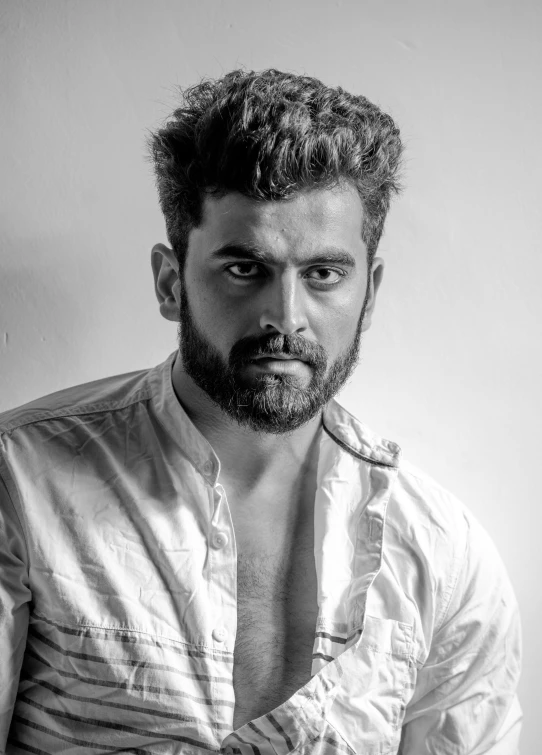 a black and white photo of a man with a beard, by Max Dauthendey, pexels contest winner, portrait of a rugged young man, jayison devadas, wearing spiky, wavy hair combed to one side