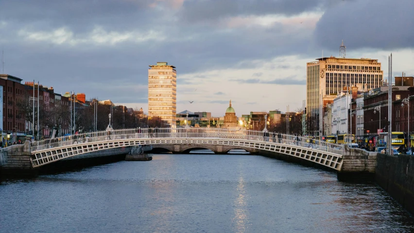 a bridge over a river with buildings in the background, inspired by Mór Than, pexels contest winner, irish genes, mies van der rohe, entire city in view, white sweeping arches