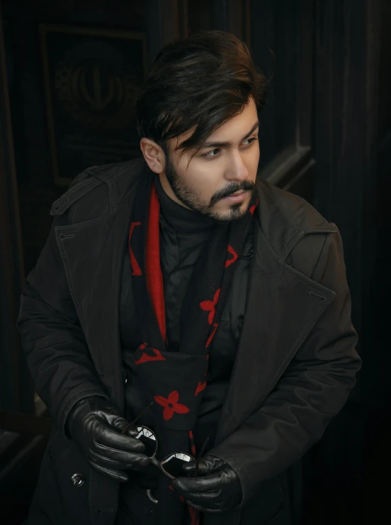 a man wearing black gloves and red scarf