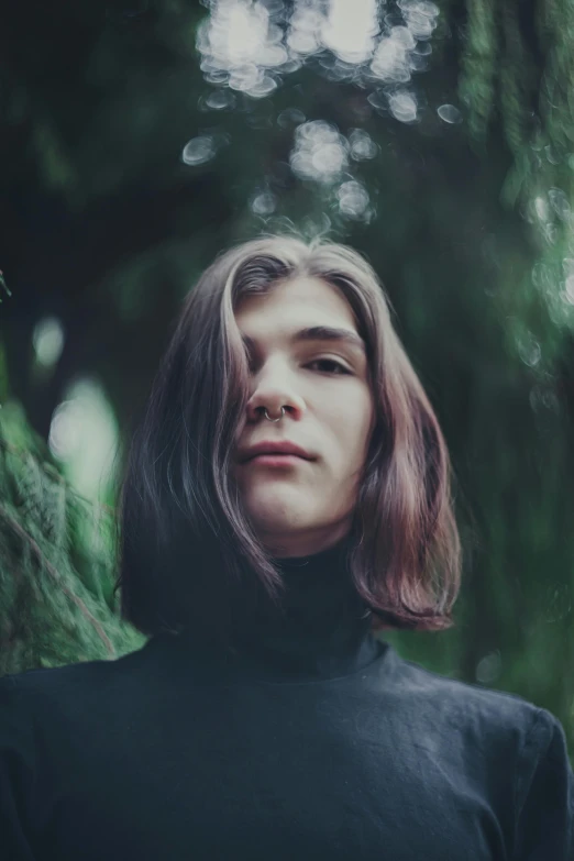 a woman standing in front of a tree, an album cover, trending on unsplash, androgynous face, maxim sukharev, black turtleneck, lush surroundings