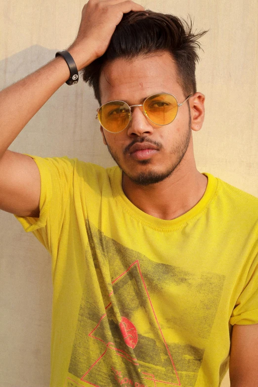 a man poses while wearing yellow tinted sunglasses