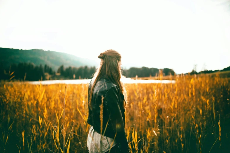 a woman is standing in the middle of a field