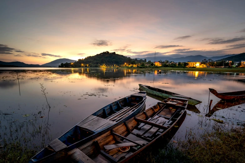 a couple of boats sitting on top of a lake, inspired by Steve McCurry, unsplash contest winner, vietnam, soft evening lighting, nepal, summer night