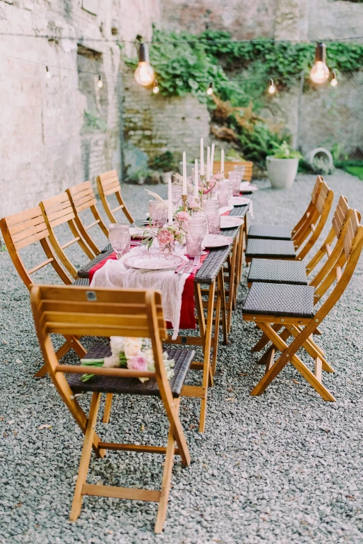 a dinner table with chairs and a pink tablecloth