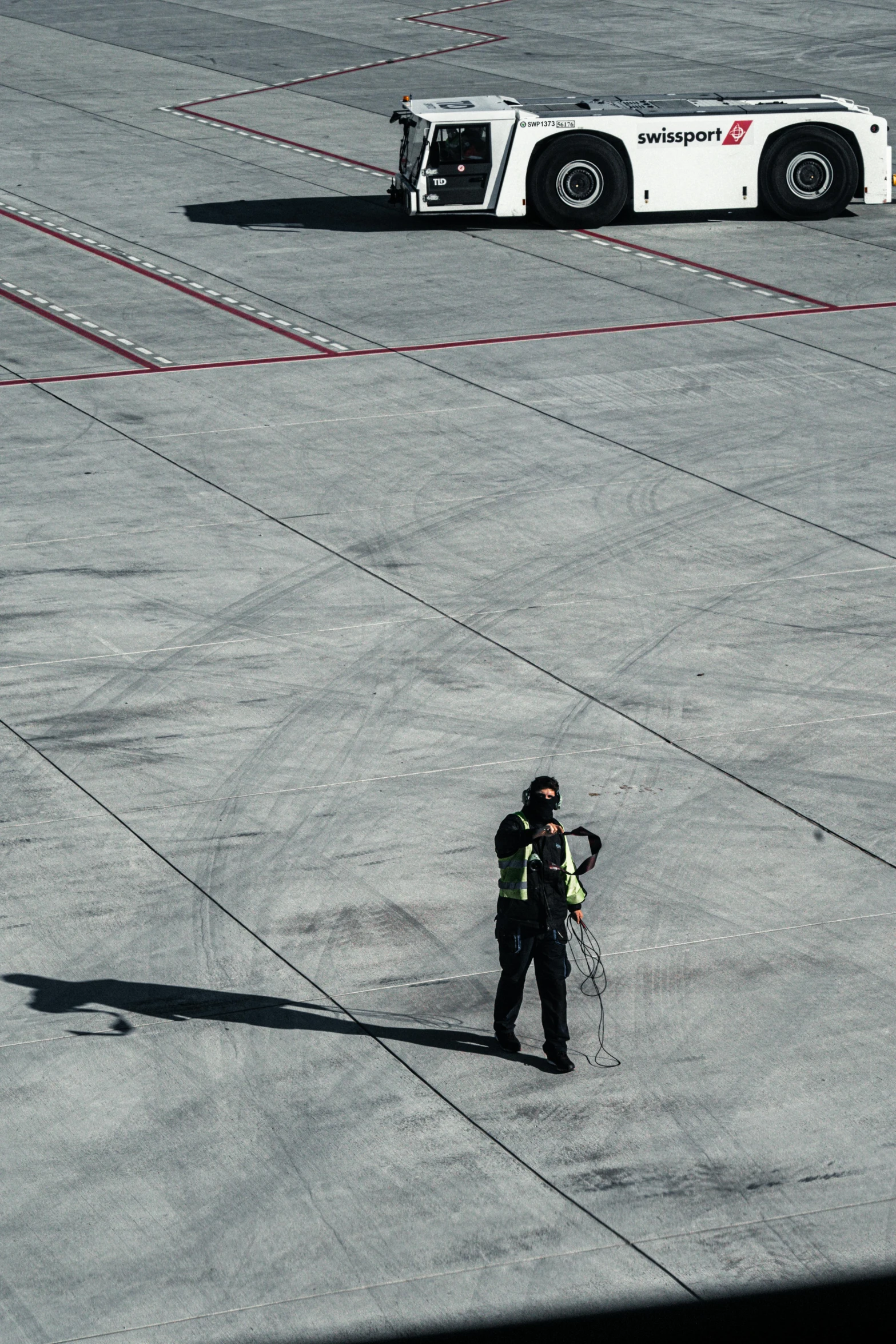 a man standing on a tarmac in front of a large truck