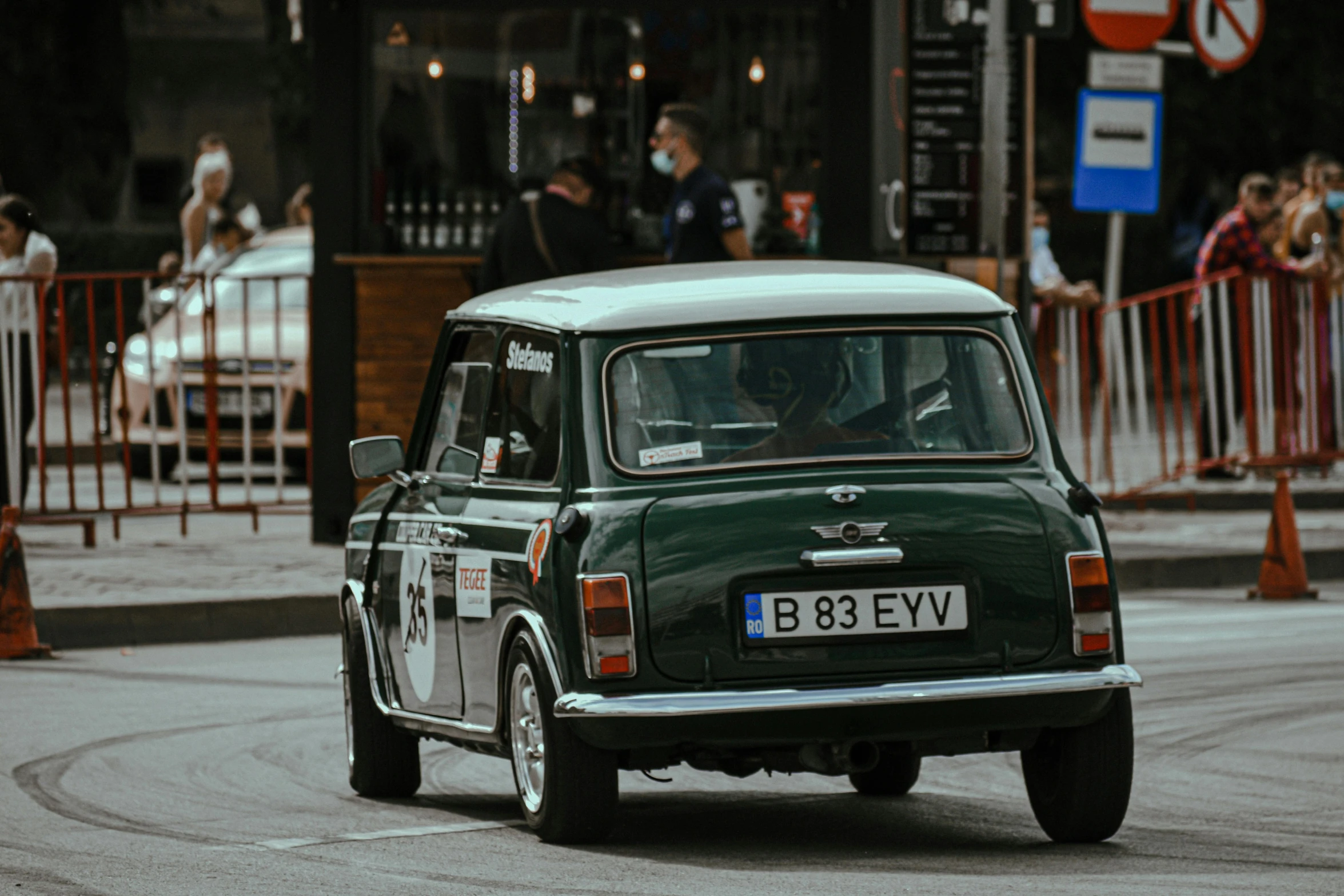 a small green car driving down a street, by Sven Erixson, pexels contest winner, mini cooper, vintage race footage, square, thumbnail