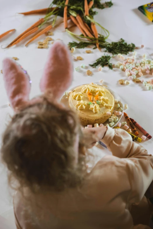 a little girl sitting at a table with a plate of food, with bunny ears, close-up shot from behind, creating a soft, creamy