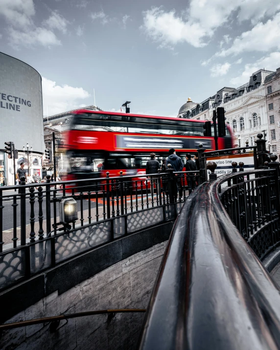 a red double decker bus driving down a street, by Joseph Severn, pexels contest winner, curved bridge, public art, square, 🚿🗝📝