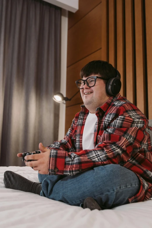 a man sitting on a bed with headphones on, featured on reddit, hurufiyya, video game icon, wearing round glasses, high resolution image, wholesome