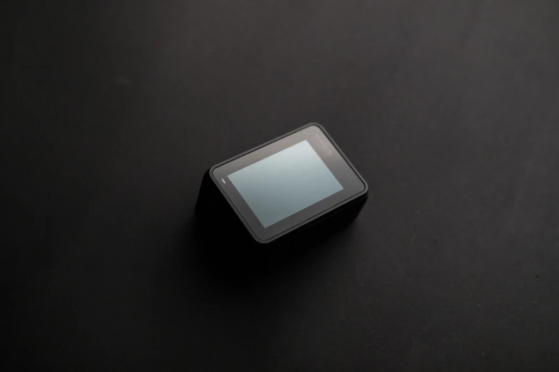 a tablet computer sitting on top of a black table, hasselblad photograph, miniature product photo, vantablack gi, square