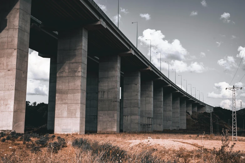 a long bridge over an empty field with power lines in it