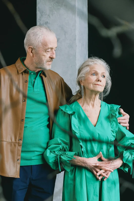 a man and a woman standing next to each other, green clothing, dementia, trending, multiple stories