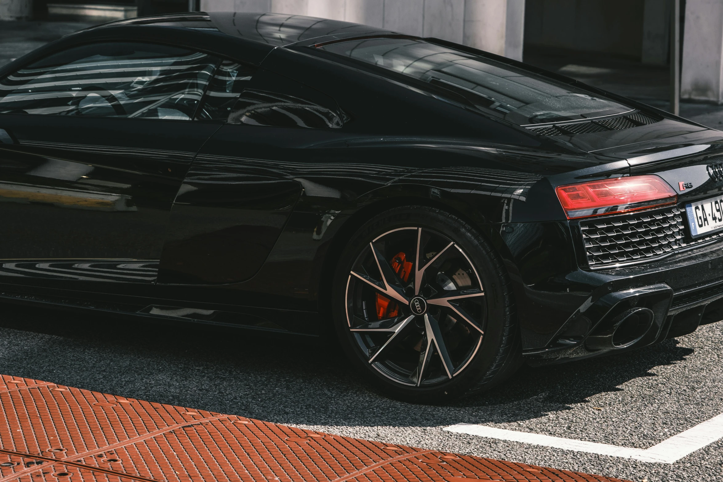 a black car parked on a street next to a building