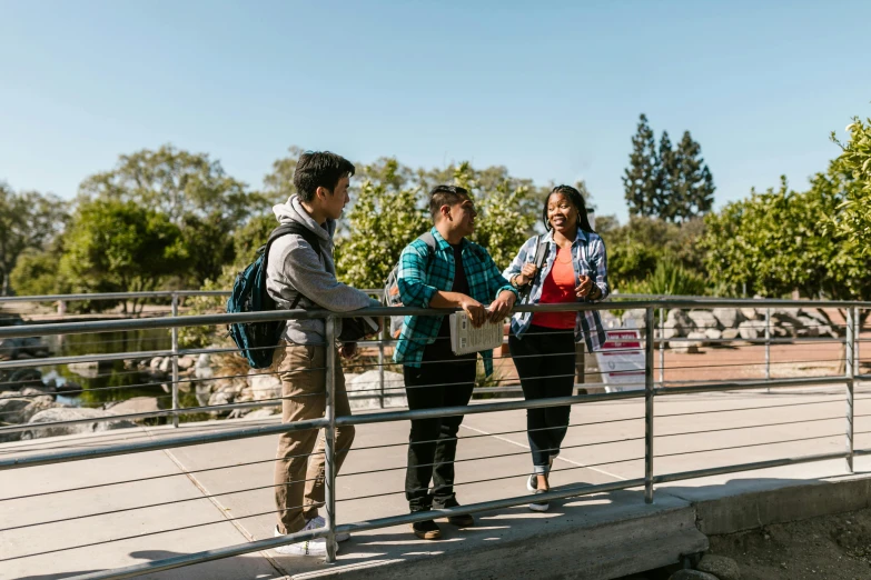 a group of people standing on top of a bridge, calarts, welcoming attitude, student, at a park