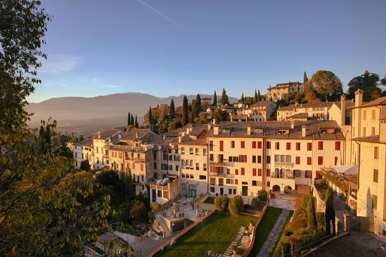 a group of buildings sitting on top of a lush green hillside, inspired by Serafino De Tivoli, pexels contest winner, renaissance, at dawn, white travertine terraces, overlooking a valley with trees, college