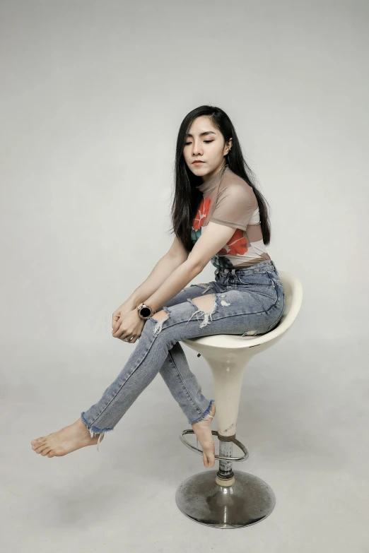 a young woman poses for a po in her pants on a chair