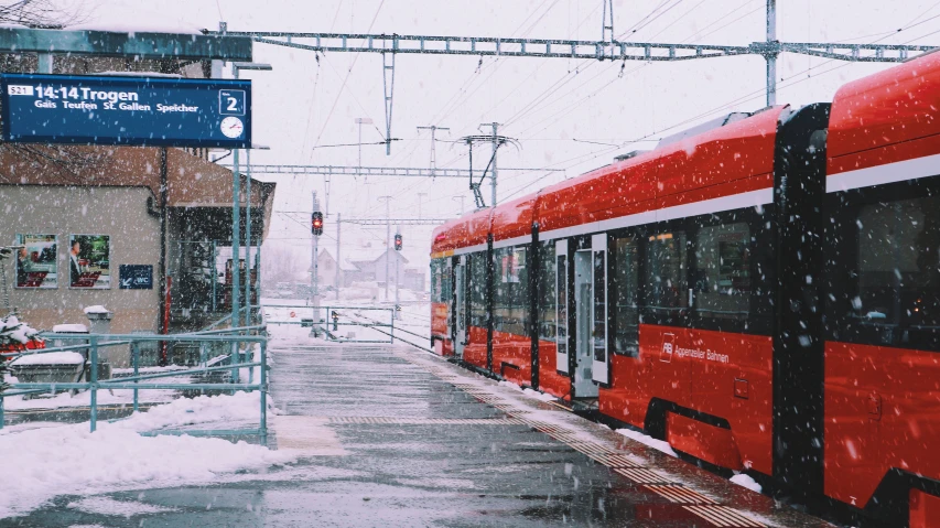 a red bus driving down a snow covered street, by Tobias Stimmer, pexels contest winner, regionalism, train station in summer, 🚿🗝📝