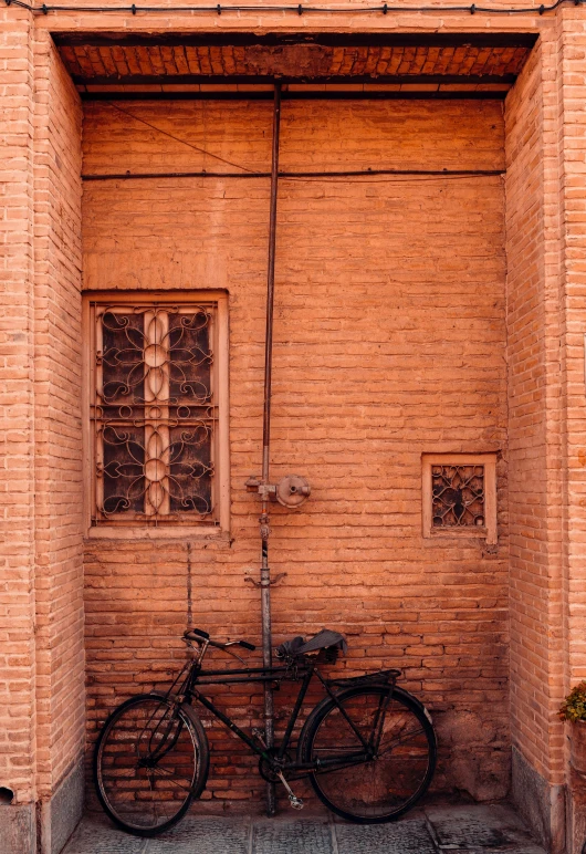 a bicycle parked in front of a brick building, inspired by Steve McCurry, persian style architecture, 2019 trending photo, ancient”, square