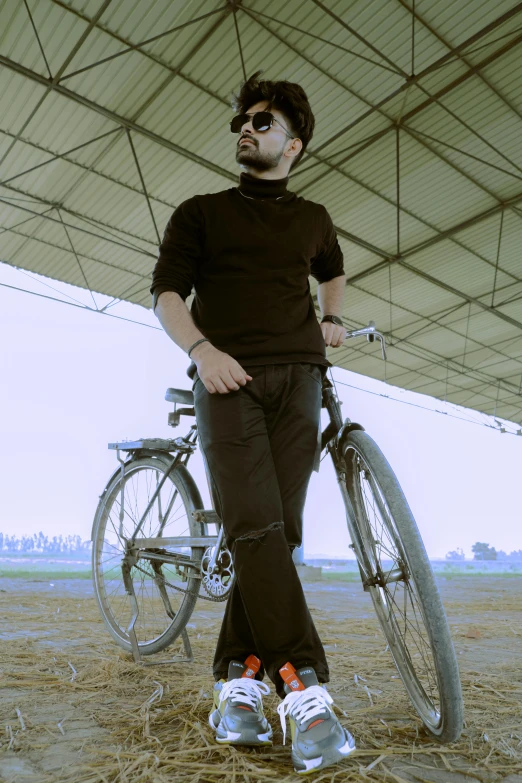 man with bicycle inside shelter in grassy area