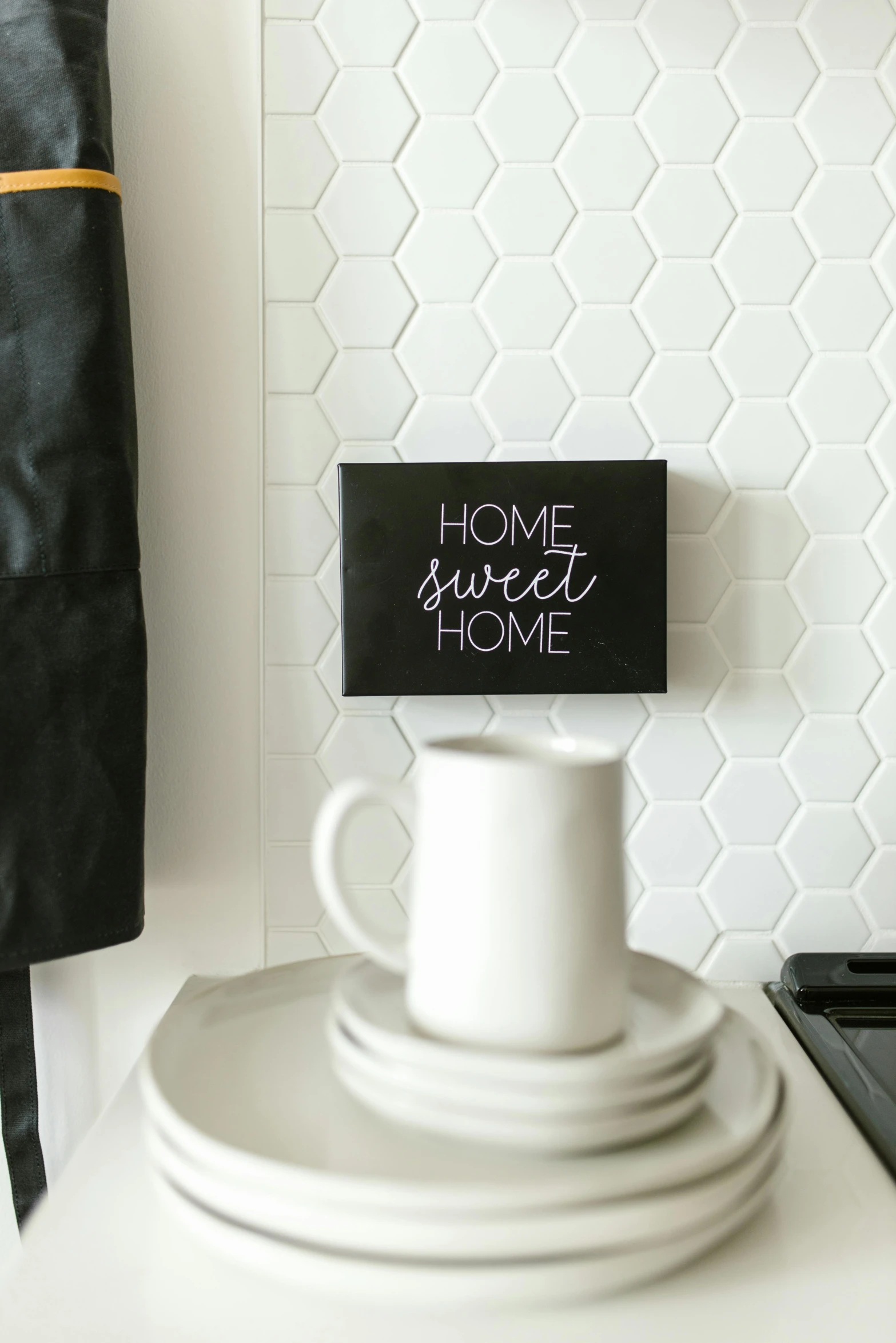 a white plate sitting on top of a kitchen counter, a picture, hexagon mesh, sweet home, all black matte product, in white lettering