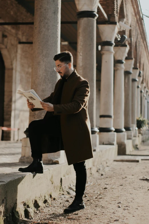 a man sitting on a ledge reading a book, pexels contest winner, renaissance, trench coat and suit, handsome, symmetrical, gif