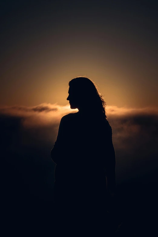 a person standing in front of a sunset, woman's profile, covered in clouds, dark. no text, ((sunset))