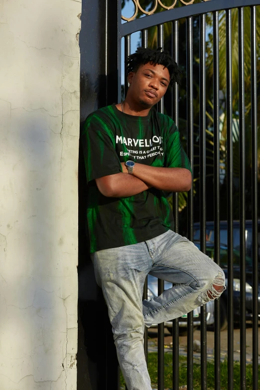 a young black man leaning against a wall