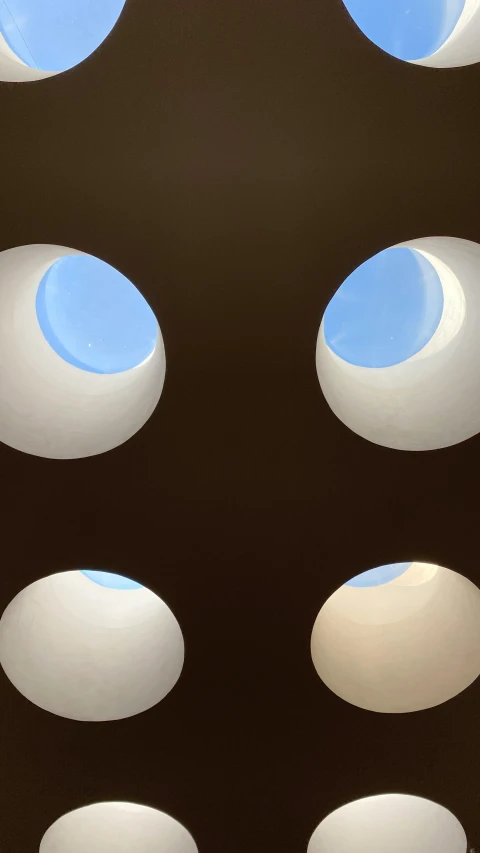 a white toilet sitting under a blue skylight, inspired by Douglas Bourgeois, flickr, conceptual art, illuminated orbs, brown holes, upclose, 4k photo”