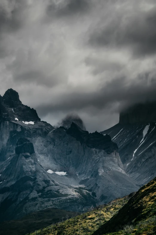 a dark storm over the mountains in cloudy skies