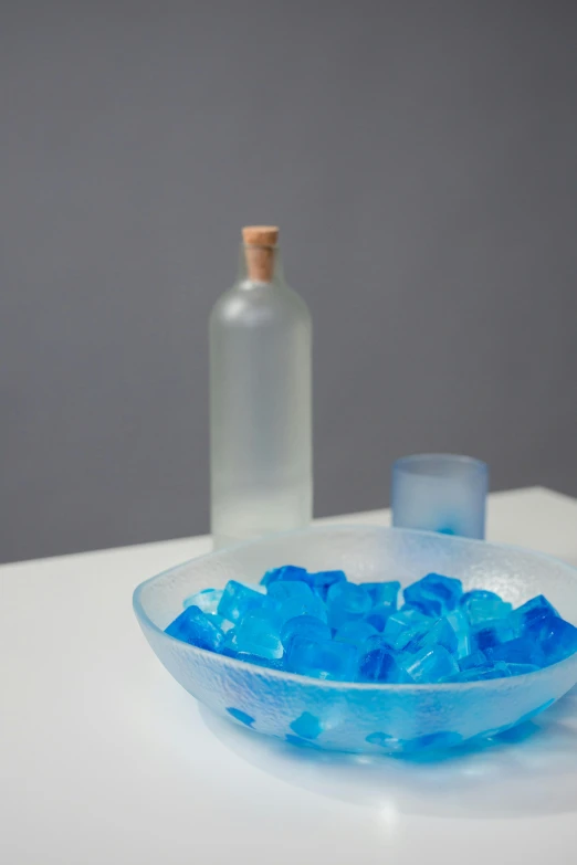 small blue gummy bears sit in a bowl on the counter