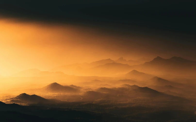 the sun is setting over a mountain range, by Adam Marczyński, unsplash contest winner, romanticism, light orange mist, unreal engine 5 lighting, moody hazy lighting, multiple stories