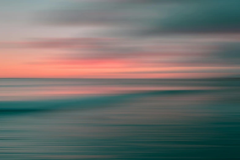 a blurry photo of the ocean at sunset, by Andrew Geddes, unsplash contest winner, minimalism, pink and teal and orange, abstract realism, desaturated, striped orange and teal