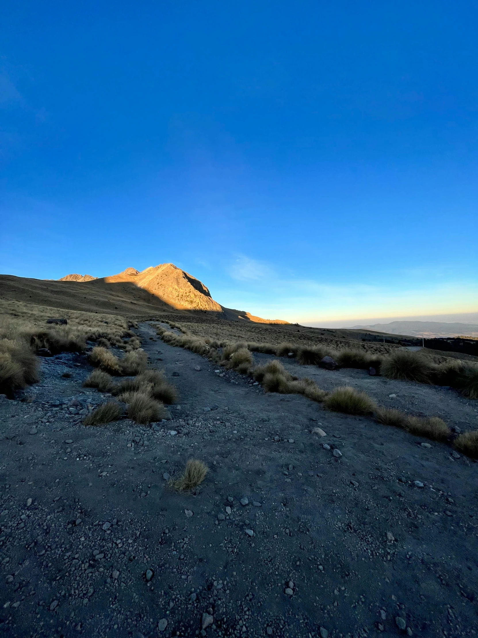 a view of the top of a mountain at sunset