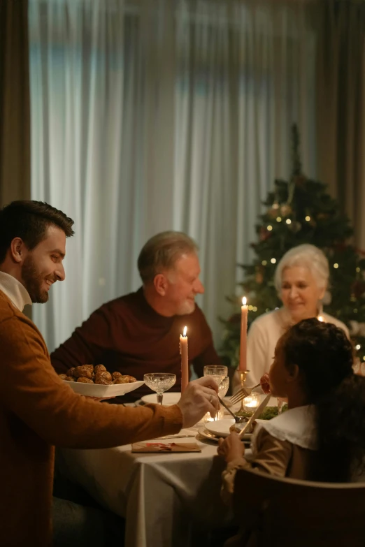 a group of people sitting around a dinner table, on a candle holder