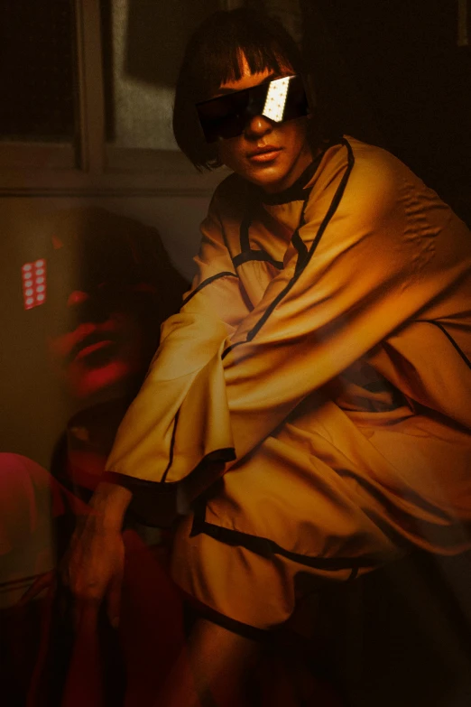 a man holding a cell phone to his ear, an album cover, inspired by Nan Goldin, visual art, yellow robe, tardigrade wearing sunglasses, action shot girl in parka, underground party