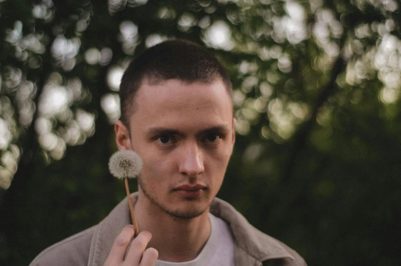 a man with a dandelion in his hand, an album cover, by Attila Meszlenyi, pexels contest winner, clean shaven wide face, portrait soft low light, brown haired, smooth pale skin