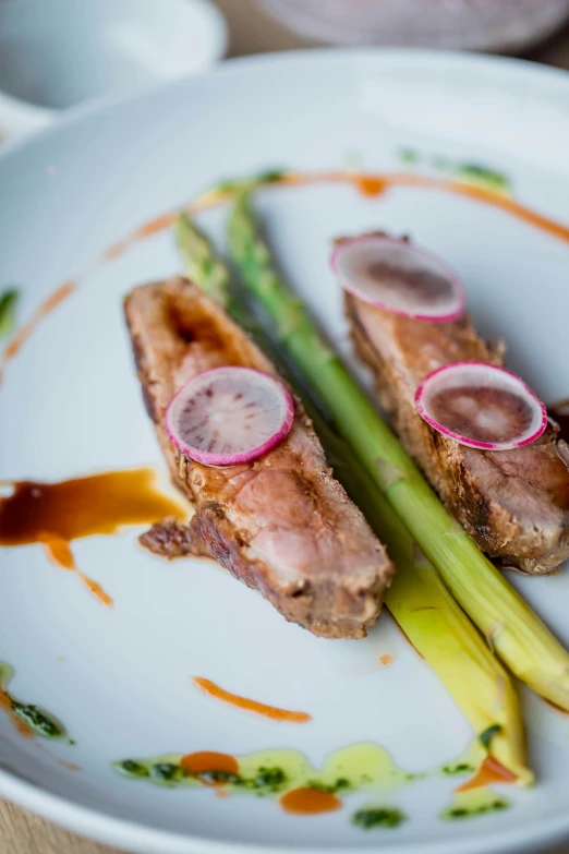 a white plate topped with meat and asparagus, by Jay Hambidge, unsplash, duck, longque chen, spectacular details, pink asparagus