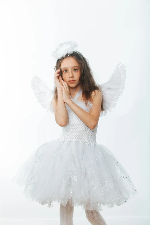 a little girl dressed in a white dress and angel wings, an album cover, pexels, frown fashion model, teen elf girl, costume desig, on white