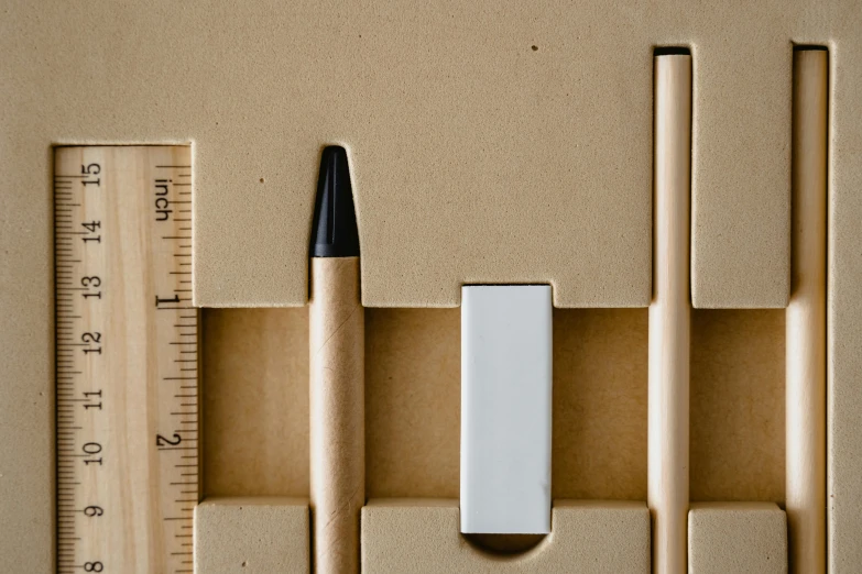 a ruler, pencil, and eraser sitting next to each other, inspired by Rachel Whiteread, unsplash, square nose, beige, sustainable, cardboard