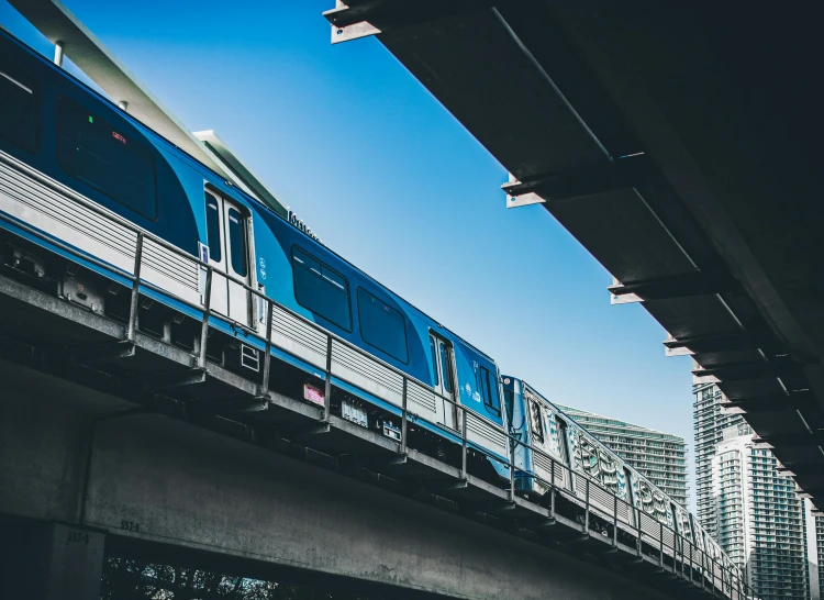 a blue and silver train traveling over a bridge, by Carey Morris, unsplash, the city of toronto, avatar image, metro, 🚿🗝📝