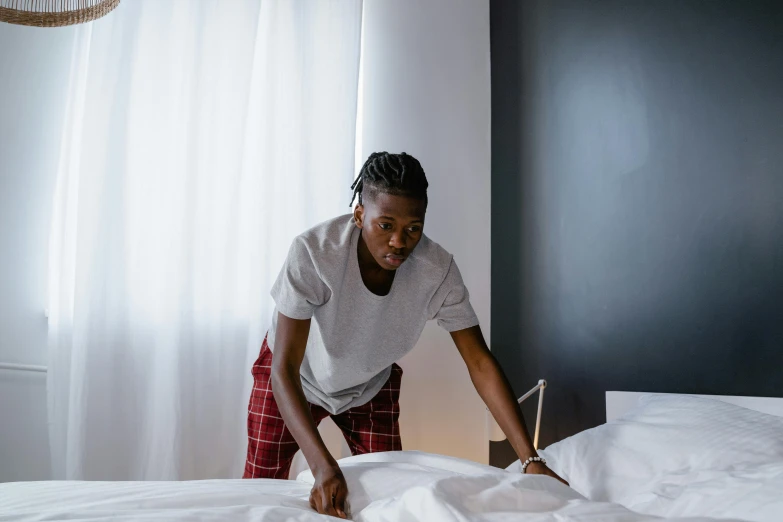 a person standing at a bed while a piece of paper sits on top of it