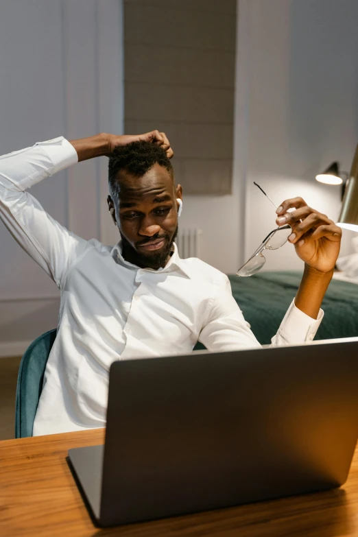 a man sitting in front of a laptop computer, trending on pexels, happening, scratching head, black man, funny professional photo, man turning into pony