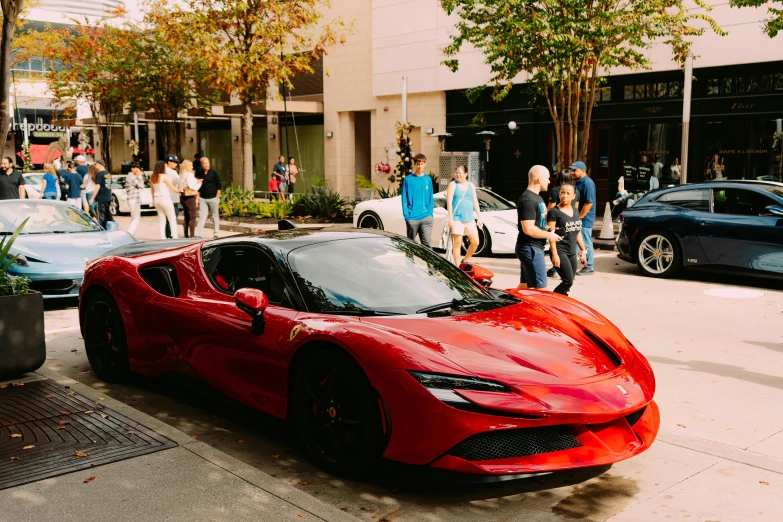 a car sits parked on a street as people stand by