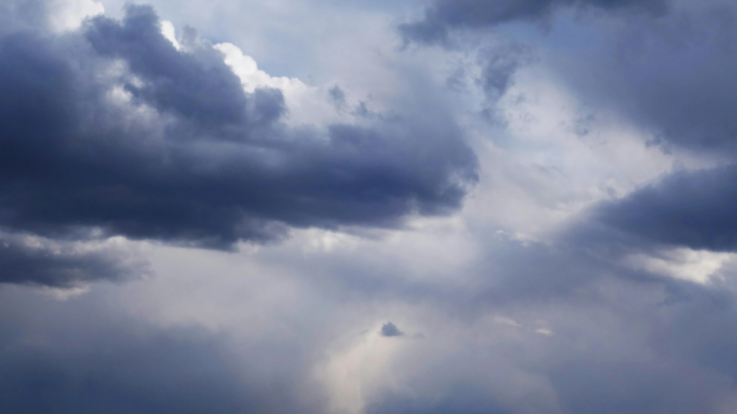 an airplane flying in front of many clouds