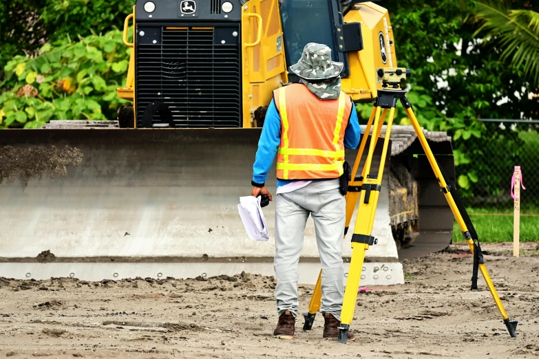 a construction worker standing in front of a bulldozer, looking at the ground, promo image, civil engineer, thumbnail