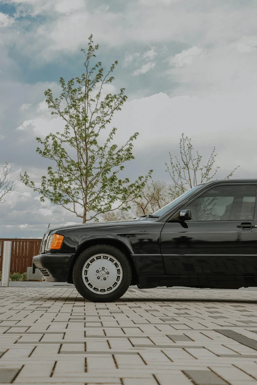 a black car parked on a brick road, a picture, by Matthias Stom, unsplash, from the 8 0 s, mercedez benz, profile image, 🚿🗝📝