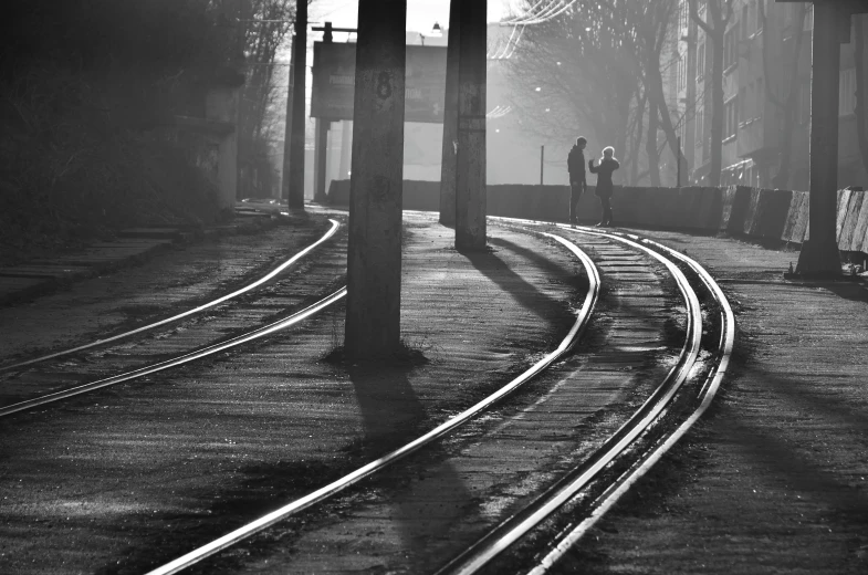 a black and white photo of a train track, a black and white photo, by Ferenc Joachim, realism, early morning light, street life, friends, ((mist))