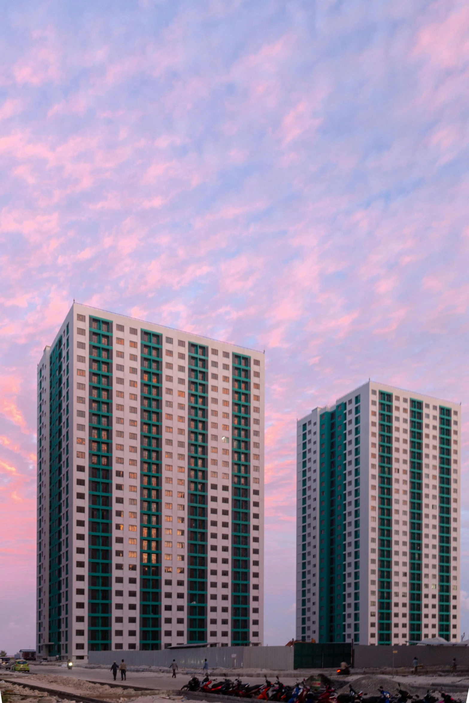 two high rise buildings against a sunset sky